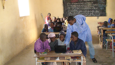 Teacher overseeing boys with computer